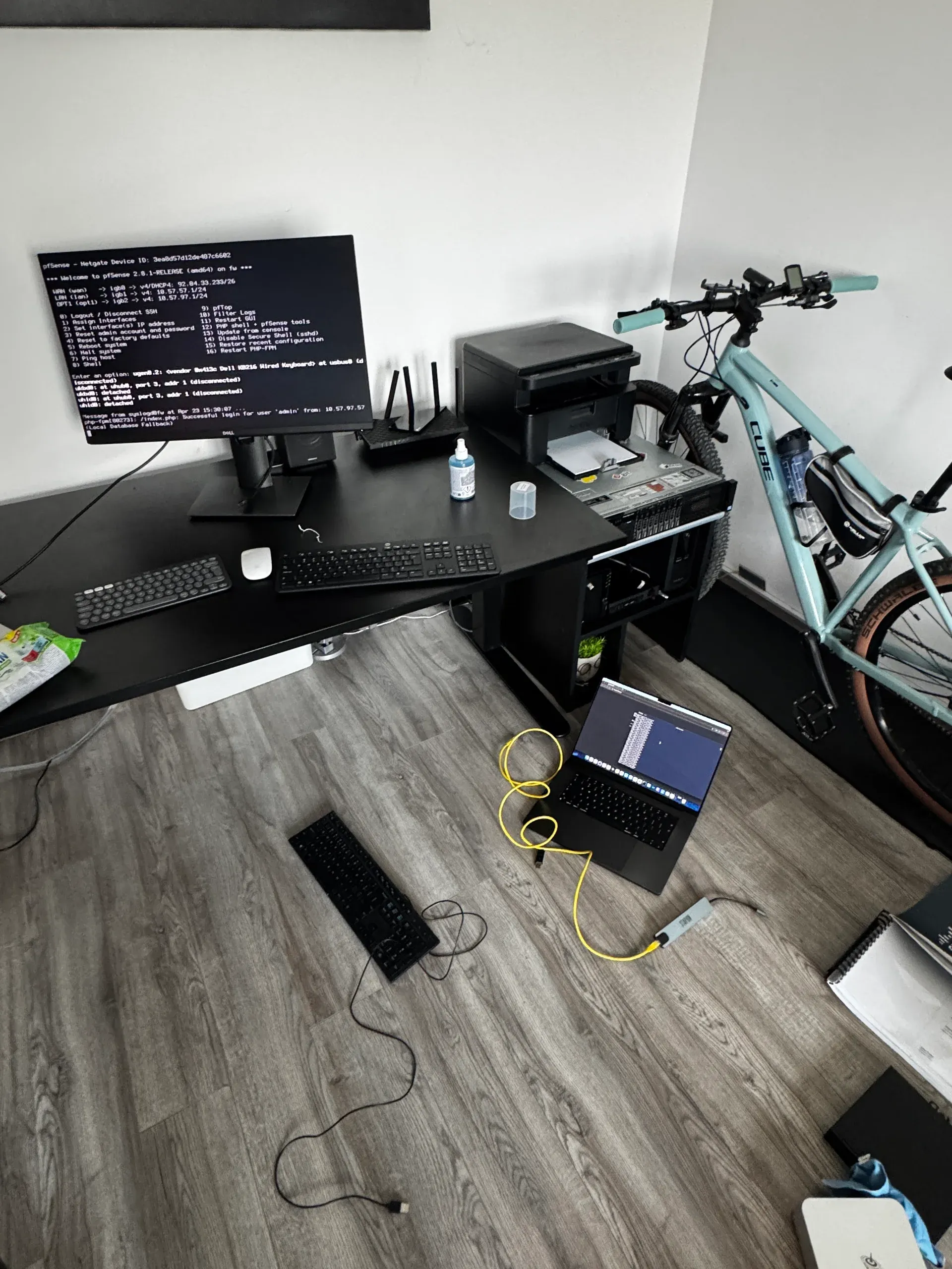 pfSense troubleshooting session — Dell KB216 on the floor, laptop for reference, pfSense box on desk